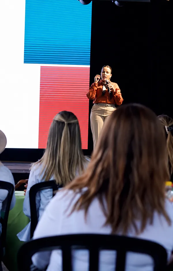 Raissa Curado palestrando para uma plateia